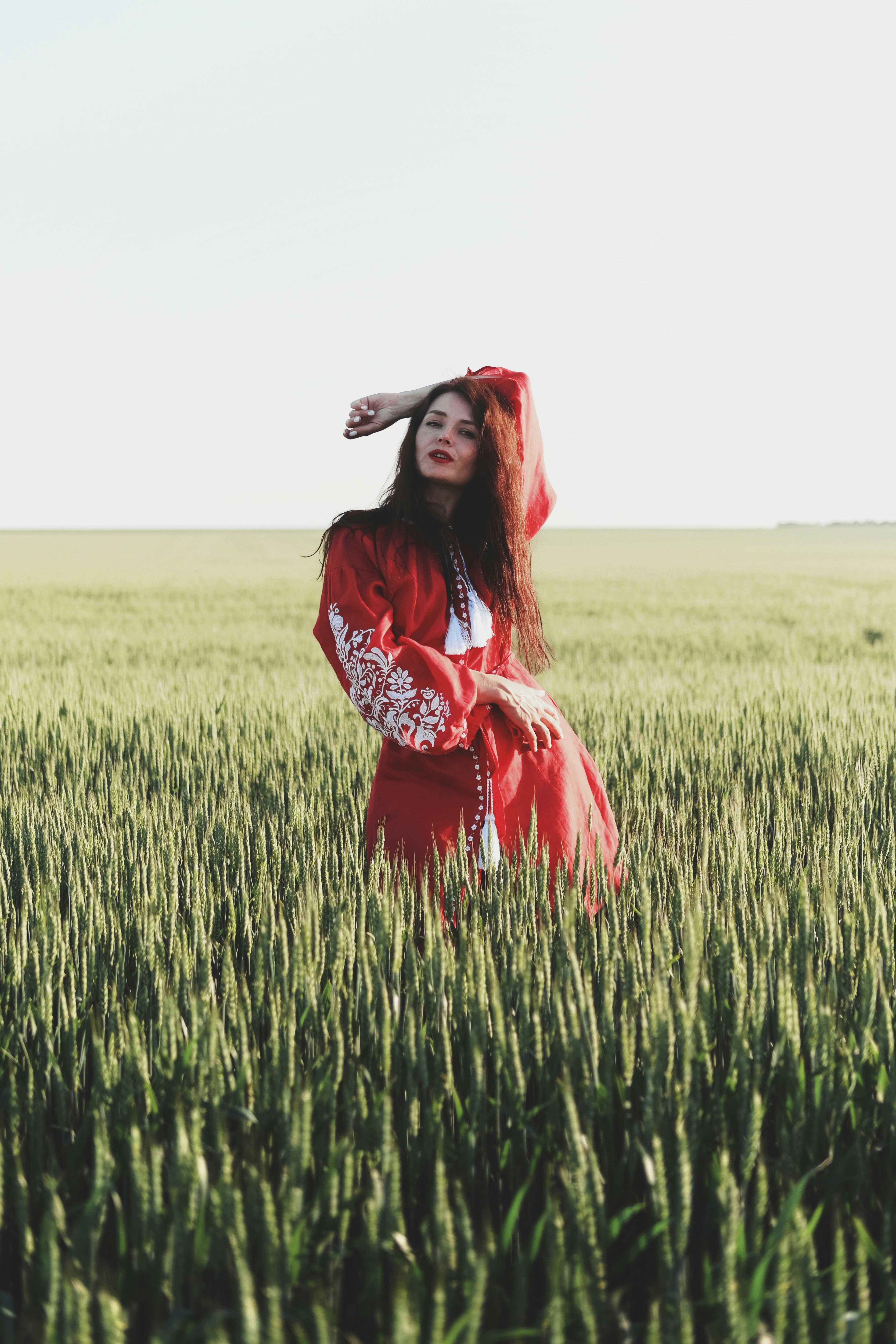 woman in black and white floral long sleeve dress standing on green grass field during daytime